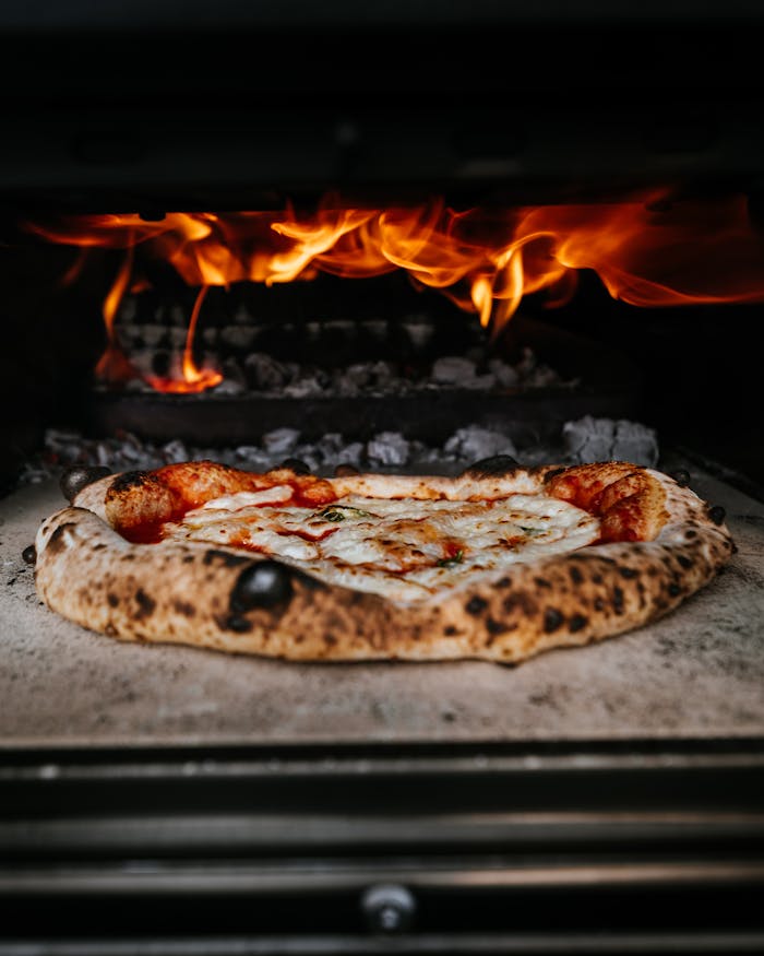 Crafting Captivating Headlines: Your awesome post title goes here Close-up of authentic pizza cooking in a wood-fired oven with flames.